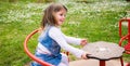 Little girl turns into a red carousel in an outdoor playground