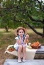 Little girl with two pigtails gathering apple in green grass background. Child Girl with red apple in summer orchard. Smiling chil Royalty Free Stock Photo