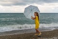 Little girl with umbrella on beach in bad weather Royalty Free Stock Photo