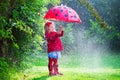 Little girl with umbrella playing in the rain Royalty Free Stock Photo
