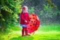 Little girl with umbrella playing in the rain Royalty Free Stock Photo