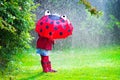 Little girl with umbrella playing in the rain Royalty Free Stock Photo