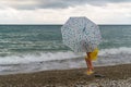 Little girl with umbrella on beach in bad weather Royalty Free Stock Photo