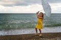 Little girl with umbrella on beach in bad weather Royalty Free Stock Photo