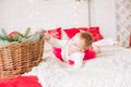 A little girl under one year old in an airy dress on a large bed in a room decorated for Christmas Royalty Free Stock Photo