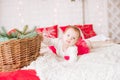 A little girl under one year old in an airy dress on a large bed in a room decorated for Christmas Royalty Free Stock Photo