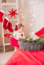 A little girl under one year old in an airy dress on a large bed in a room decorated for Christmas Royalty Free Stock Photo