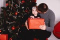 Little girl unpacking gift with dad near Christmas tree.Happy girl unpacks holidays gift box. Happy lovely family Royalty Free Stock Photo