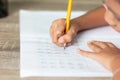 A little girl use a yellow pencil writing in a notebook Royalty Free Stock Photo