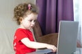 Little girl uses laptop. copy space. child and computer games, addiction.