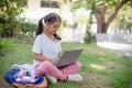 little girl uses a laptop to learn at school. The child smiles happily and gets knowledge remotely