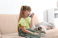 Little girl using asthma inhaler near cat at home Royalty Free Stock Photo