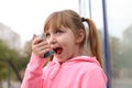 Little girl using asthma inhaler outdoors Royalty Free Stock Photo