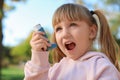 Little girl using asthma inhaler outdoor Royalty Free Stock Photo