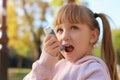 Little girl using asthma inhaler outdoors Royalty Free Stock Photo