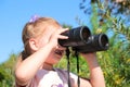 Little girl using binoculars in the forest. Exploring the world. Outdoor activities Royalty Free Stock Photo