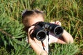 Little girl using binoculars in the forest. Exploring the world. Outdoor activities. Adventure Royalty Free Stock Photo