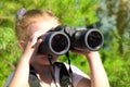 Little girl using binoculars in the forest. Exploring the world. Outdoor activities Royalty Free Stock Photo