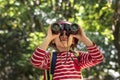 Little girl using binoculars in the forest Royalty Free Stock Photo
