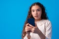 Little girl using mobile phone.against blue background Royalty Free Stock Photo