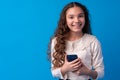 Little girl using mobile phone.against blue background Royalty Free Stock Photo