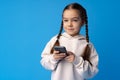 Little girl using mobile phone.against blue background Royalty Free Stock Photo