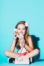 Little girl using pink analogue phone