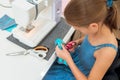 Little girl using a sewing machine to sew on a piece of fabric. Creative tailoring workshops for children Royalty Free Stock Photo