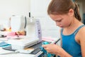 Little girl using a sewing machine to sew on a piece of fabric. Creative tailoring workshops for children Royalty Free Stock Photo