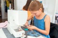 Little girl using a sewing machine to sew on a piece of fabric. Royalty Free Stock Photo