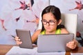 Little girl using a Tablet PC and an Ebook for homework