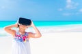 Little girl using VR virtual reality goggles. Adorable kid look into the virtual glasses on white beach Royalty Free Stock Photo