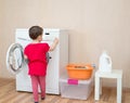 Little girl using washing machine