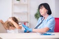 Little girl visiting old female doctor Royalty Free Stock Photo