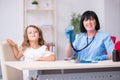 Little girl visiting old female doctor Royalty Free Stock Photo