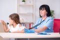 Little girl visiting old female doctor Royalty Free Stock Photo
