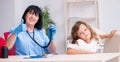 Little girl visiting old female doctor Royalty Free Stock Photo