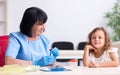 Little girl visiting old female doctor Royalty Free Stock Photo