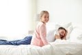 Little girl waking her sleeping father up in bed Royalty Free Stock Photo