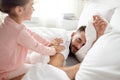 Little girl waking her sleeping father up in bed Royalty Free Stock Photo