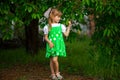 Little girl walk in green garden in summer day Royalty Free Stock Photo