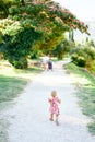 Little girl walking along the gravel path in the green park Royalty Free Stock Photo