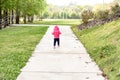 Child standing in tall grass on a sunny day outsideA little girl is walking along the path at a park Royalty Free Stock Photo