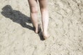 Little girl walking barefoot on the beach sand. A great composition for the design with a little girl with dirty legs walk on sand Royalty Free Stock Photo