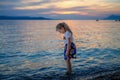 Little girl walking on beautiful ocean beach. Happy preschool child play by sunset on sea beach. Family vacations with Royalty Free Stock Photo