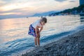 Little girl walking on beautiful ocean beach. Happy preschool child play by sunset on sea beach. Family vacations with Royalty Free Stock Photo