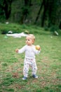 Little girl walking in a green meadow with an apple in her hand Royalty Free Stock Photo