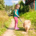 Little girl walking with her ??dog on a leash Royalty Free Stock Photo