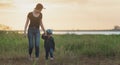 Little girl walking in the nature with her mom, Mother holding hands of her daughter. Royalty Free Stock Photo