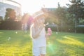 A little girl is walking in the park blowing up soap bubbles. Have fun on a sunny summer day Royalty Free Stock Photo